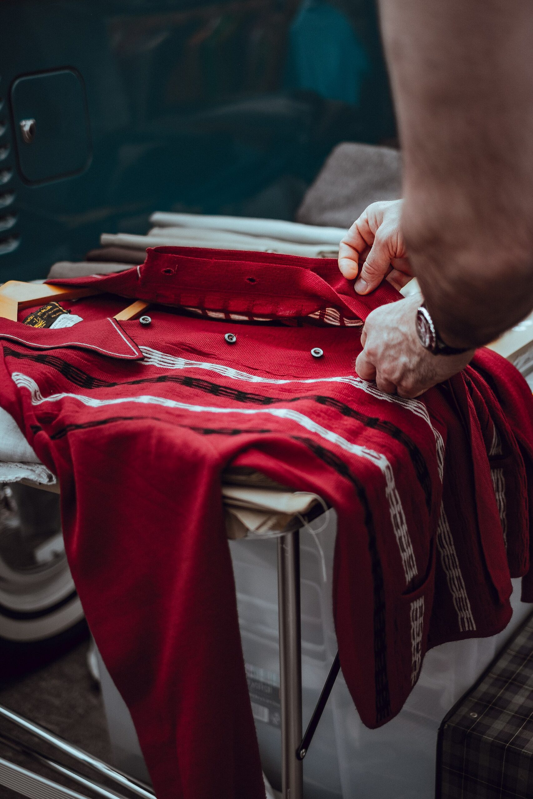 A deep red knit longsleeve being folded