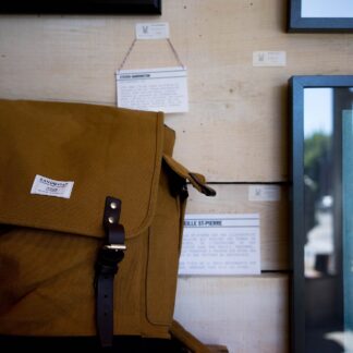 A waxed-canvas daypack standing upright