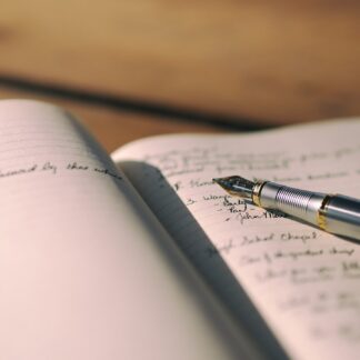 A fountain pen resting on a handwritten journal page